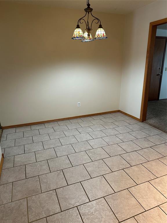 spare room featuring a chandelier