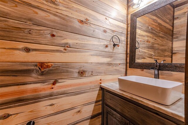 bathroom featuring wood walls and vanity