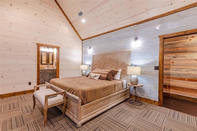 bedroom featuring visible vents, connected bathroom, wood walls, high vaulted ceiling, and baseboards