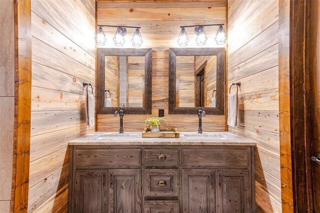 full bathroom with double vanity, wooden walls, and a sink