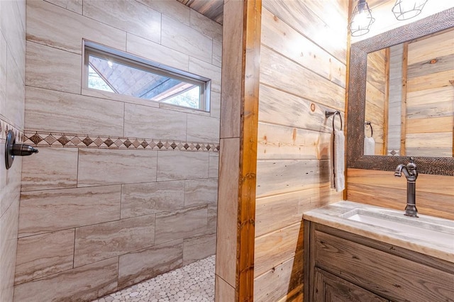 full bath featuring a tile shower and vanity