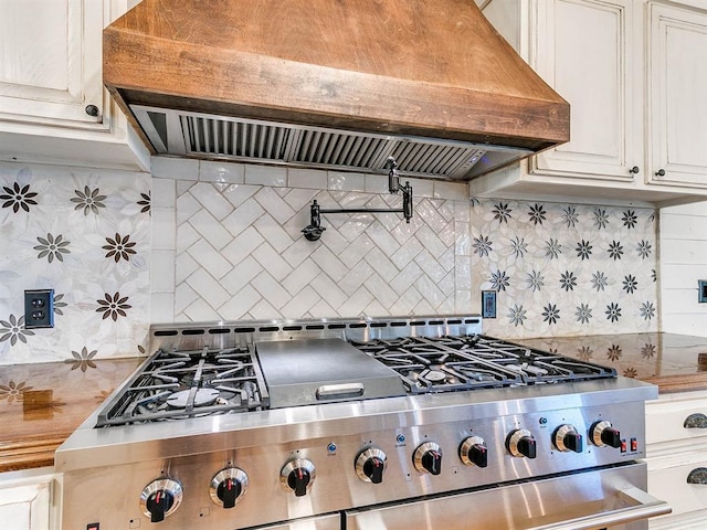 kitchen featuring tasteful backsplash, high end stainless steel range, and exhaust hood