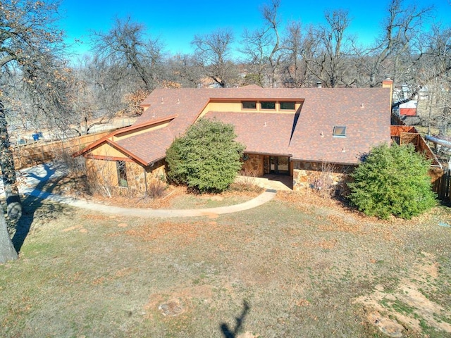 exterior space featuring stone siding and a yard