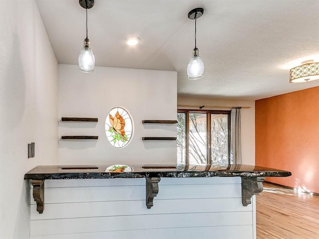 kitchen with decorative light fixtures and wood finished floors