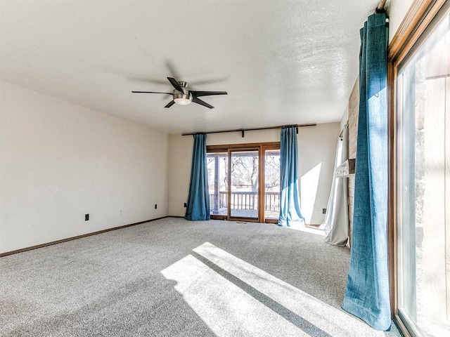 spare room with carpet floors, ceiling fan, a textured ceiling, and baseboards