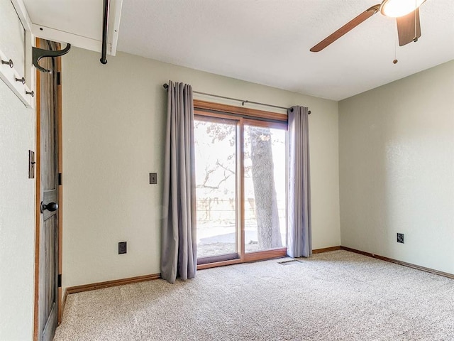 carpeted empty room featuring visible vents, baseboards, and a ceiling fan