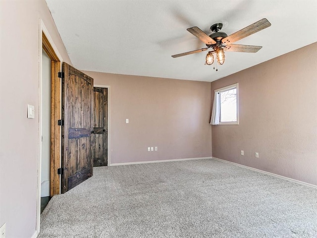 unfurnished room featuring carpet, a ceiling fan, and baseboards