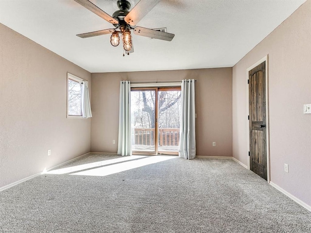 spare room with a ceiling fan, carpet, and baseboards