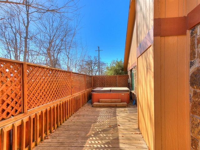 wooden deck featuring a hot tub