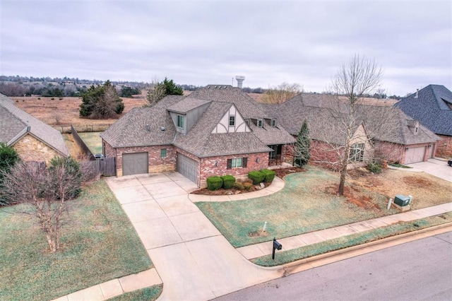 view of front of home featuring brick siding, roof with shingles, concrete driveway, an attached garage, and a front yard