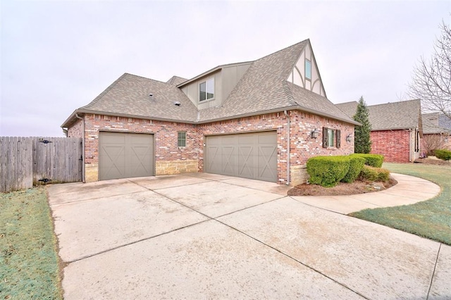 view of front of home with a garage, fence, concrete driveway, and roof with shingles