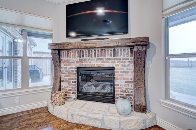 room details with a brick fireplace, baseboards, and wood finished floors