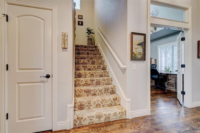 stairway with baseboards and wood finished floors