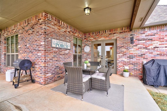 view of patio featuring french doors, a grill, and outdoor dining area