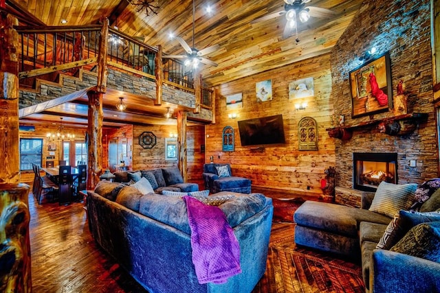 living room featuring high vaulted ceiling, wooden ceiling, ceiling fan with notable chandelier, dark wood-type flooring, and wood walls