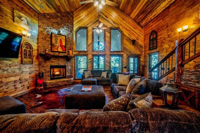 living room with stairway, a fireplace, wood ceiling, and wooden walls