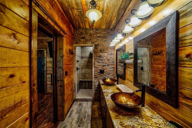 interior space with wood walls, wood ceiling, dark wood finished floors, and a sink