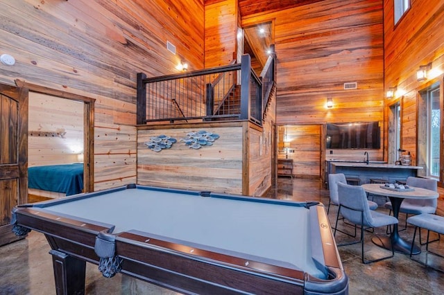 recreation room featuring pool table, wood walls, and a high ceiling