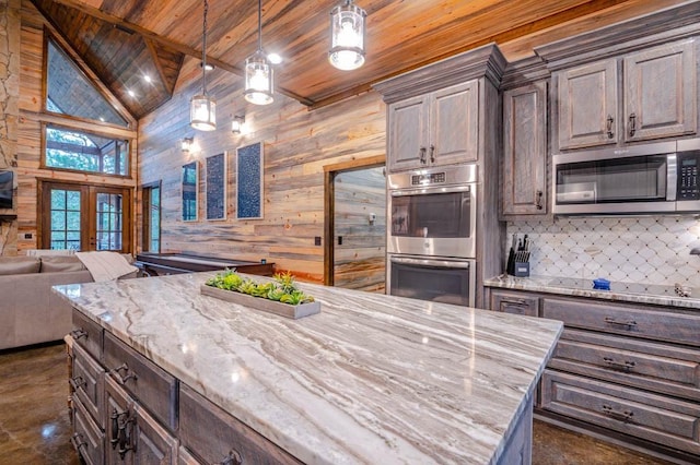 kitchen with wooden ceiling, dark brown cabinetry, open floor plan, appliances with stainless steel finishes, and decorative light fixtures