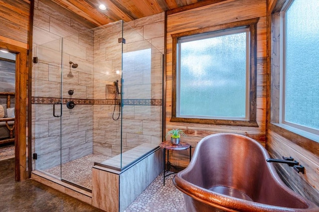 bathroom featuring a freestanding bath, wooden ceiling, and a shower stall