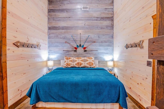 bedroom featuring visible vents and wood walls