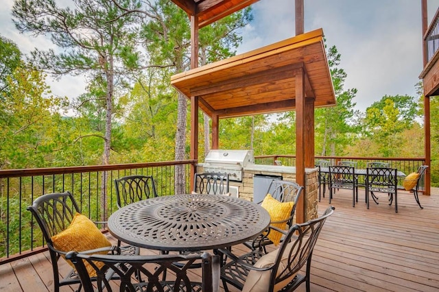 wooden terrace featuring outdoor dining space, an outdoor kitchen, and area for grilling