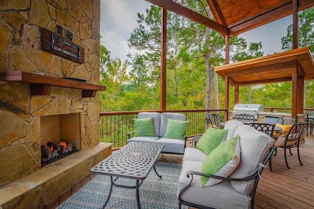 wooden terrace featuring a grill and an outdoor living space with a fireplace