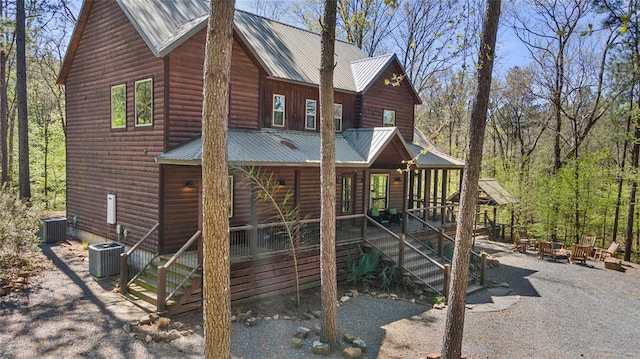 view of playground featuring stairs, an outdoor fire pit, a porch, and central air condition unit