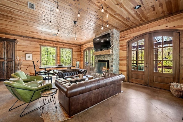 living area with finished concrete flooring, wooden ceiling, a healthy amount of sunlight, and french doors