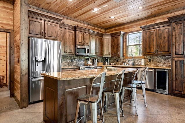 kitchen with wood ceiling, beverage cooler, stainless steel appliances, and backsplash