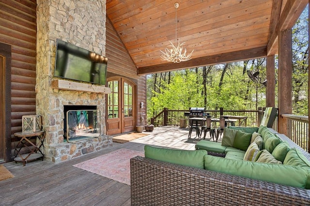 living area with high vaulted ceiling, a notable chandelier, an outdoor stone fireplace, wood ceiling, and hardwood / wood-style floors