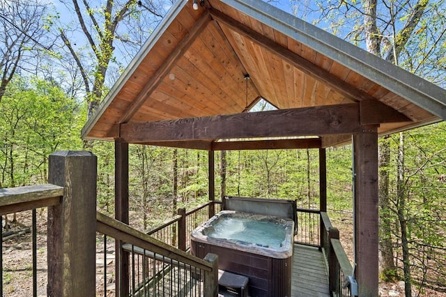 deck featuring a hot tub and a gazebo