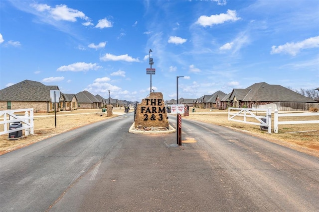 view of road with a residential view, a gated entry, and street lights