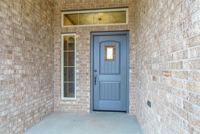 doorway to property with brick siding