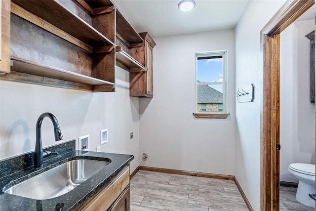 washroom with laundry area, baseboards, a sink, washer hookup, and electric dryer hookup