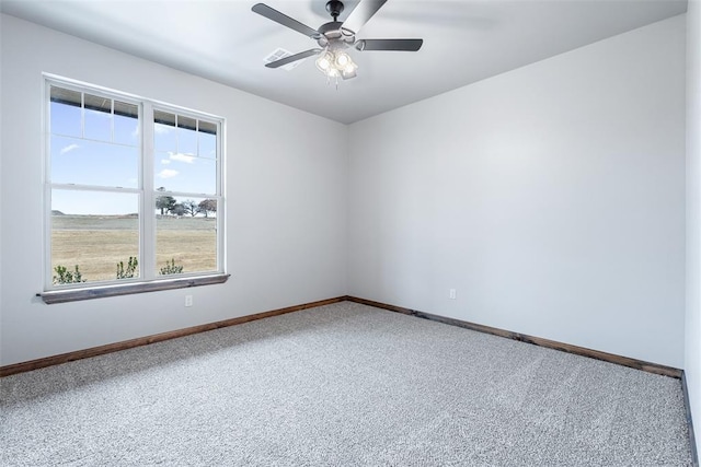 carpeted empty room with a ceiling fan and baseboards