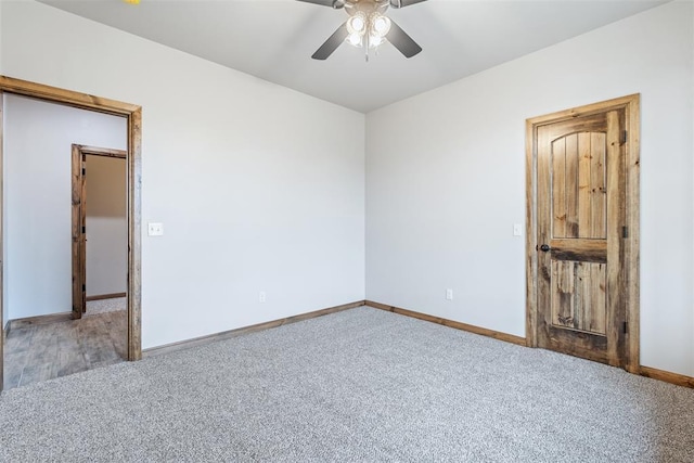 carpeted empty room with ceiling fan and baseboards