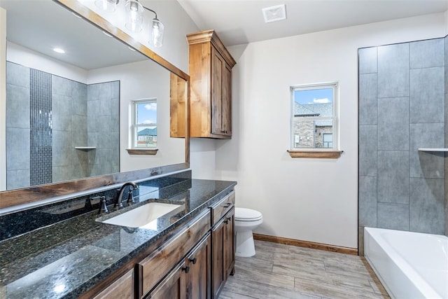 full bath featuring visible vents, baseboards, toilet, a bathtub, and vanity