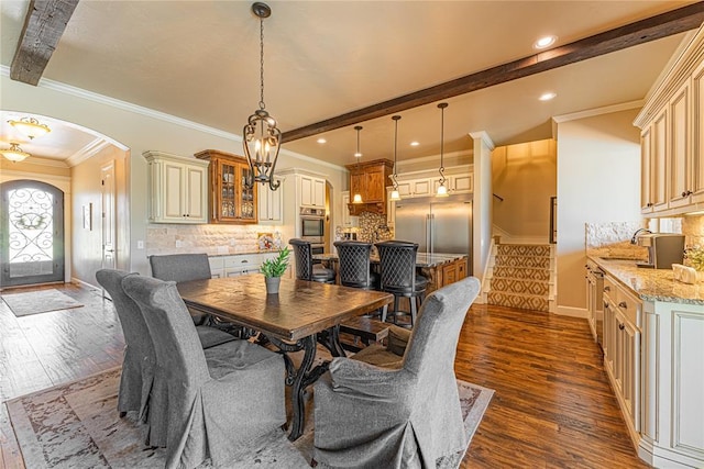 dining room with crown molding, arched walkways, baseboards, dark wood-style floors, and stairway