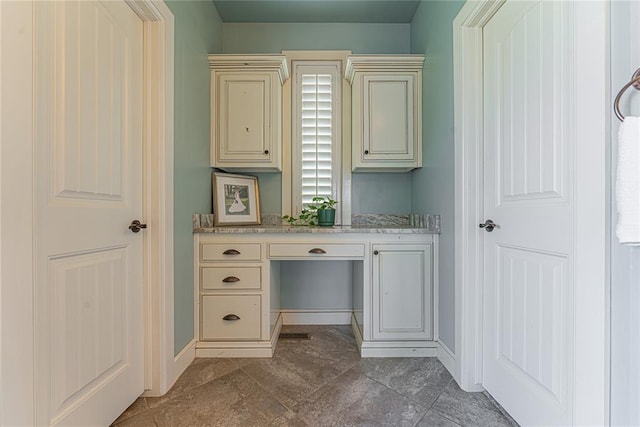 home office with baseboards and built in desk