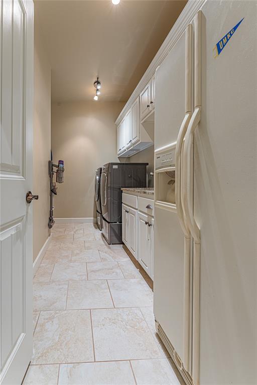 clothes washing area featuring cabinet space and washing machine and dryer