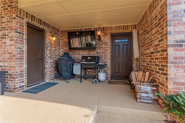 property entrance with brick siding and a porch