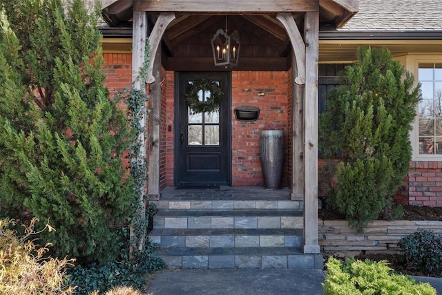 view of exterior entry featuring brick siding