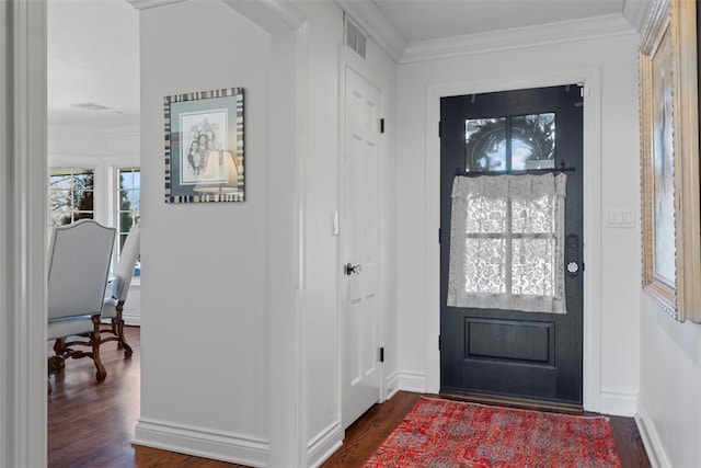 foyer entrance featuring visible vents, dark wood-type flooring, baseboards, and ornamental molding