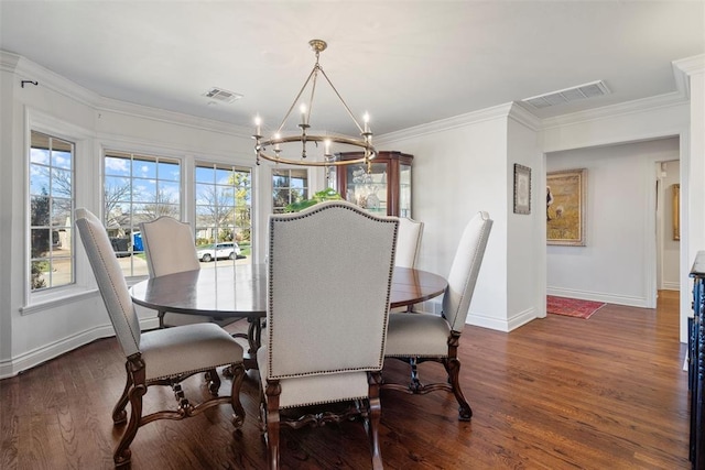 dining room featuring visible vents, wood finished floors, an inviting chandelier, and ornamental molding