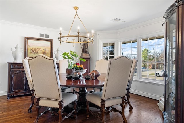 dining area featuring visible vents, dark wood-type flooring, crown molding, and an inviting chandelier