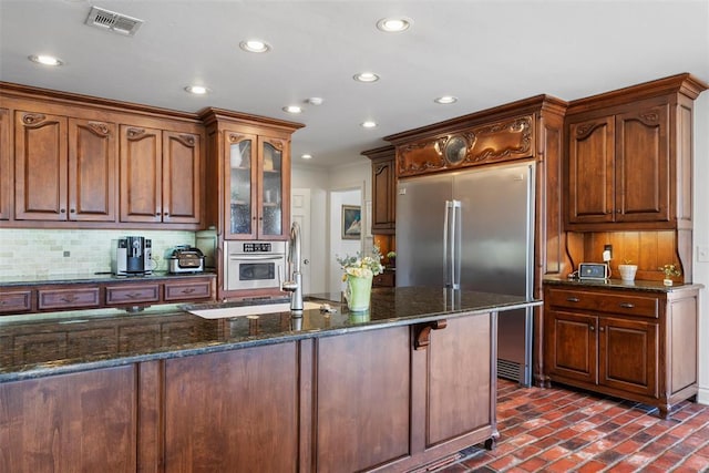 kitchen featuring visible vents, recessed lighting, brick floor, appliances with stainless steel finishes, and backsplash