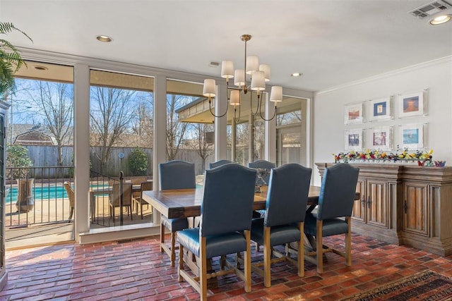 dining room featuring a notable chandelier, visible vents, brick floor, and ornamental molding