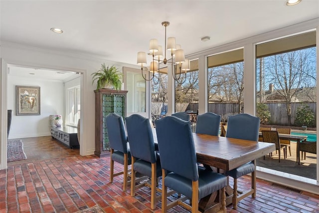 dining area featuring recessed lighting, crown molding, brick floor, baseboards, and a chandelier