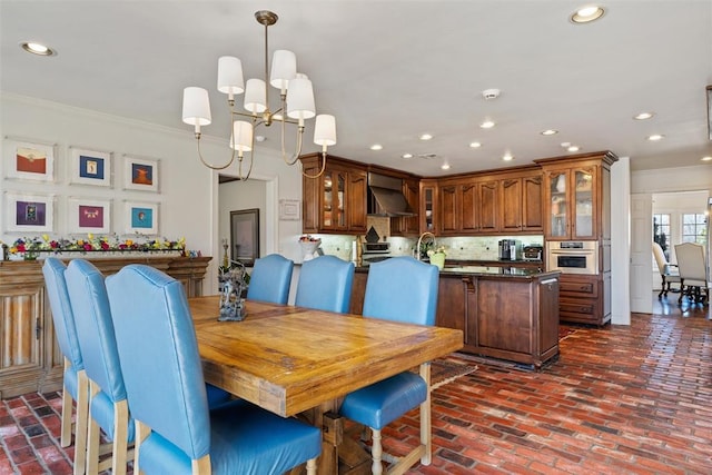 dining space featuring brick floor, recessed lighting, a chandelier, and crown molding